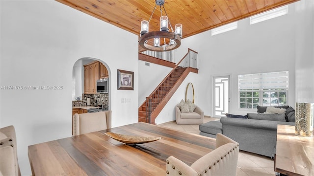 living room featuring wood ceiling, a towering ceiling, a chandelier, and light tile patterned flooring