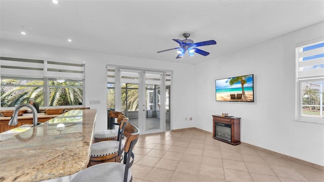 dining area featuring sink, french doors, ceiling fan, and light tile patterned flooring