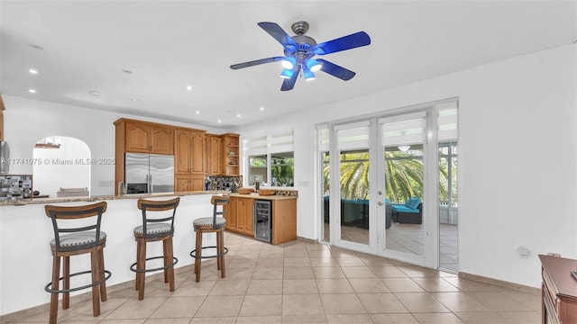 kitchen featuring wine cooler, plenty of natural light, a kitchen breakfast bar, and built in fridge