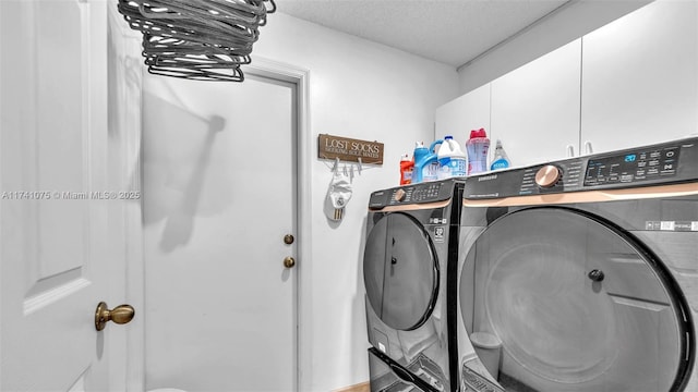 washroom featuring cabinets, a textured ceiling, and independent washer and dryer