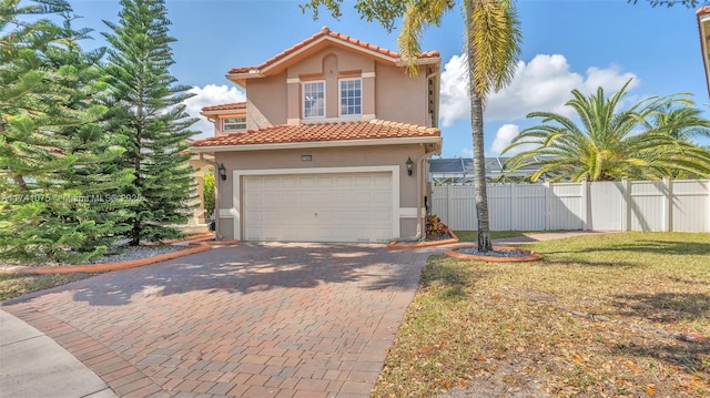 mediterranean / spanish home featuring a garage and a front yard