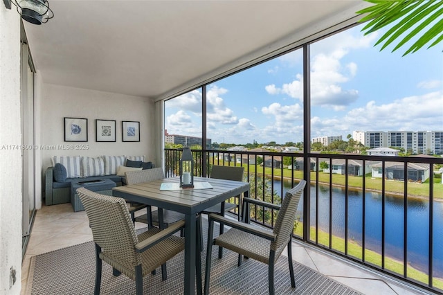 sunroom featuring a water view