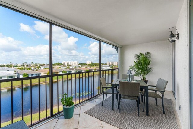 sunroom featuring a water view