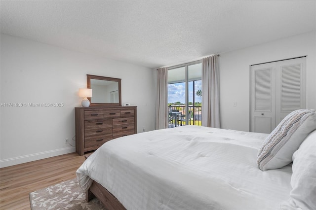 bedroom with access to exterior, a closet, a textured ceiling, and light wood-type flooring