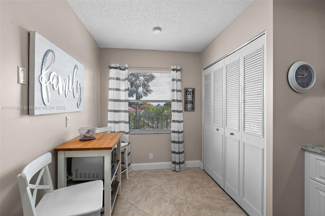 office area featuring light tile patterned flooring and a textured ceiling