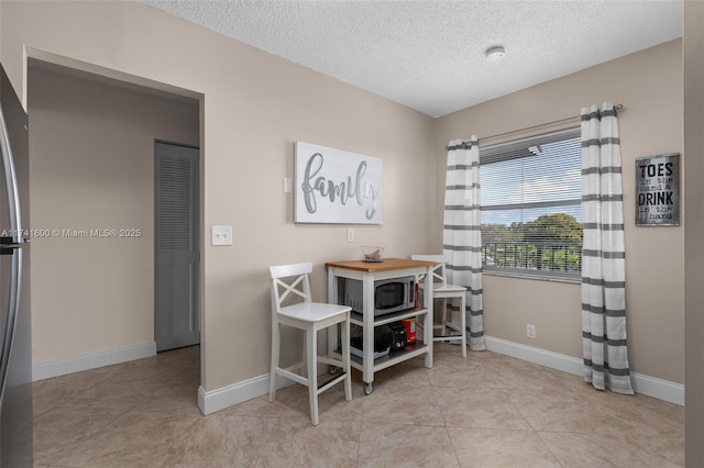 office area with light tile patterned floors and a textured ceiling