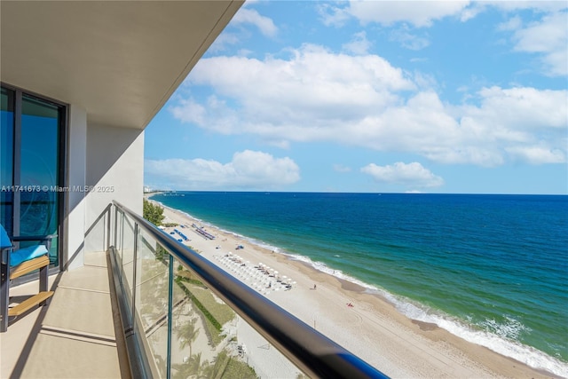 balcony featuring a water view and a beach view