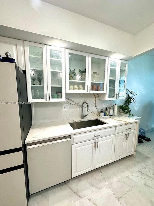 bar featuring tasteful backsplash, dishwasher, sink, and white cabinets