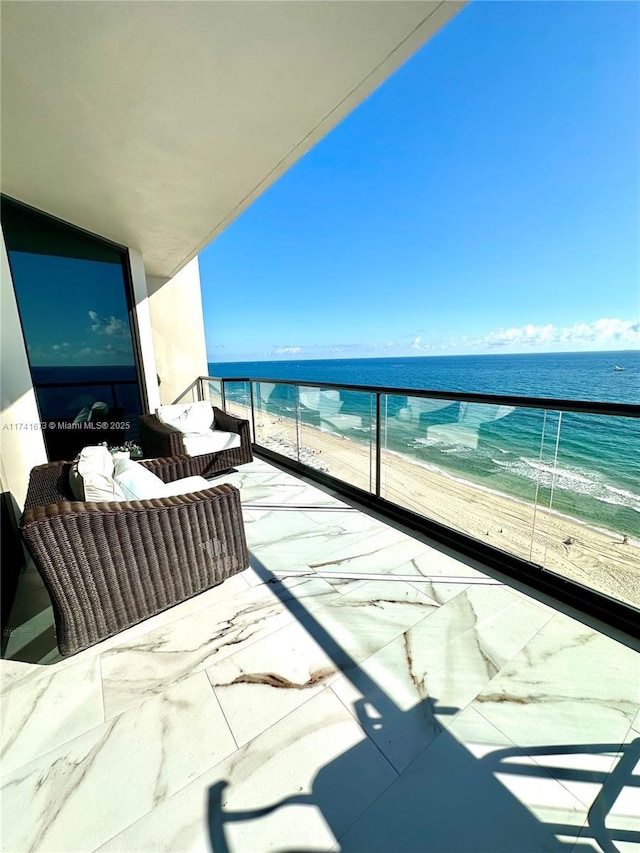 balcony featuring a view of the beach and a water view