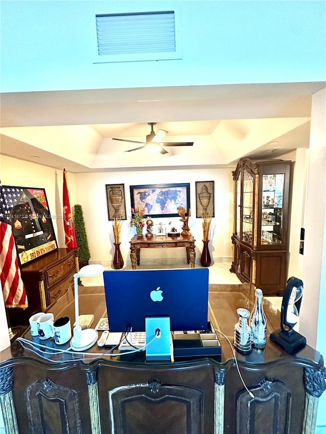 interior space featuring ceiling fan and a tray ceiling