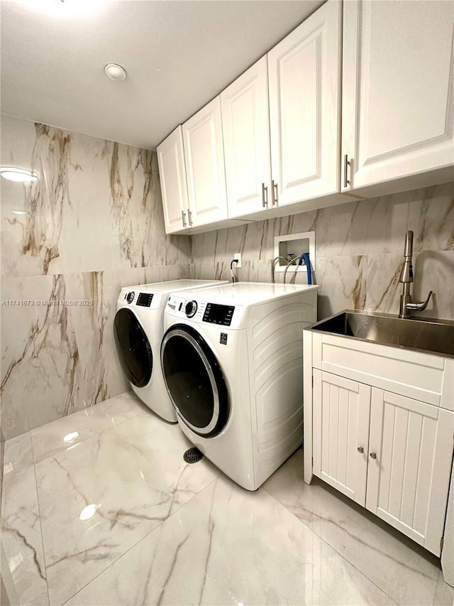 washroom featuring sink, cabinets, and washing machine and clothes dryer