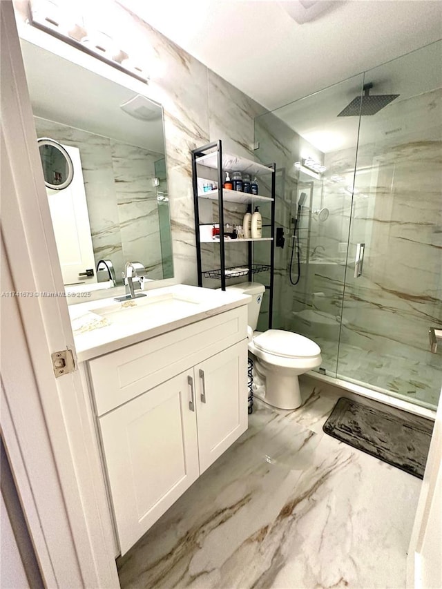 bathroom with vanity, toilet, tile walls, and a shower with shower door