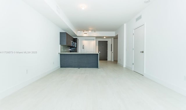 kitchen with rail lighting, kitchen peninsula, and light hardwood / wood-style floors