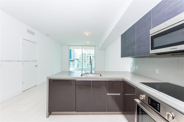 kitchen featuring appliances with stainless steel finishes, sink, and kitchen peninsula