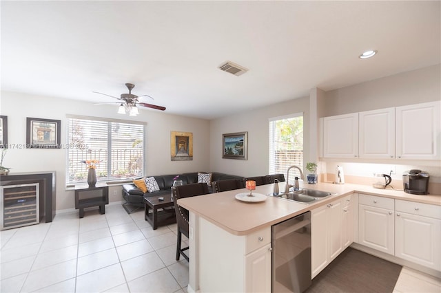 kitchen featuring white cabinetry, sink, stainless steel dishwasher, and kitchen peninsula