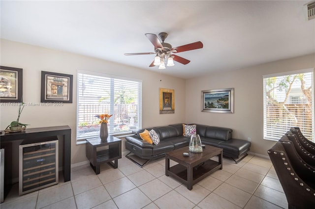 tiled living room featuring a healthy amount of sunlight, beverage cooler, and ceiling fan