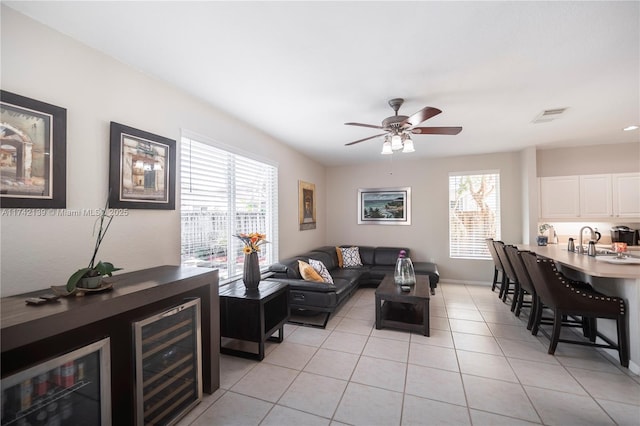 tiled living room with ceiling fan and sink