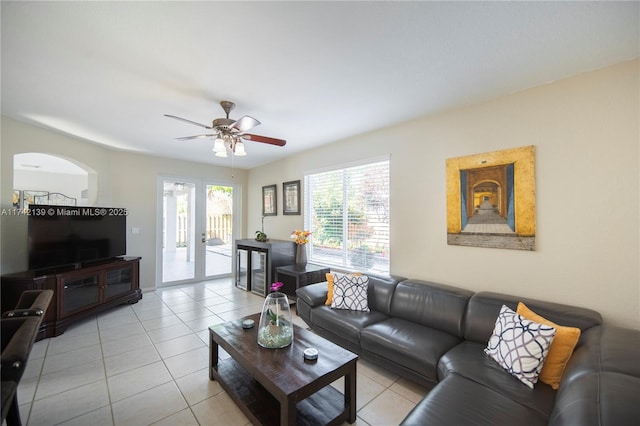 tiled living room with ceiling fan and french doors