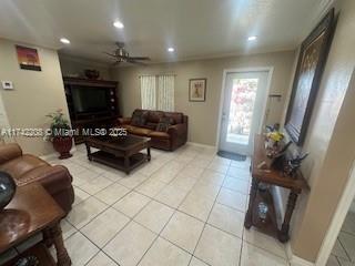 living room featuring ceiling fan and light tile patterned floors