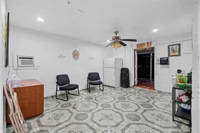 sitting room featuring a wall unit AC and ceiling fan