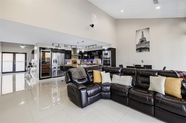 tiled living room featuring sink, high vaulted ceiling, and rail lighting