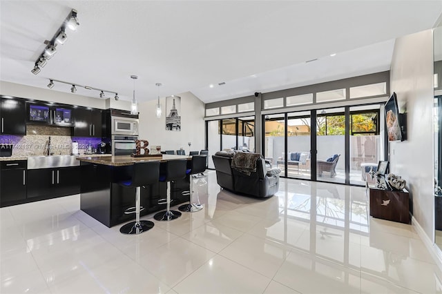 kitchen featuring pendant lighting, a breakfast bar, appliances with stainless steel finishes, a kitchen island, and decorative backsplash