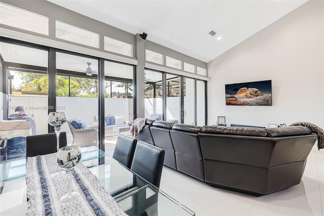 living room featuring high vaulted ceiling and light tile patterned flooring