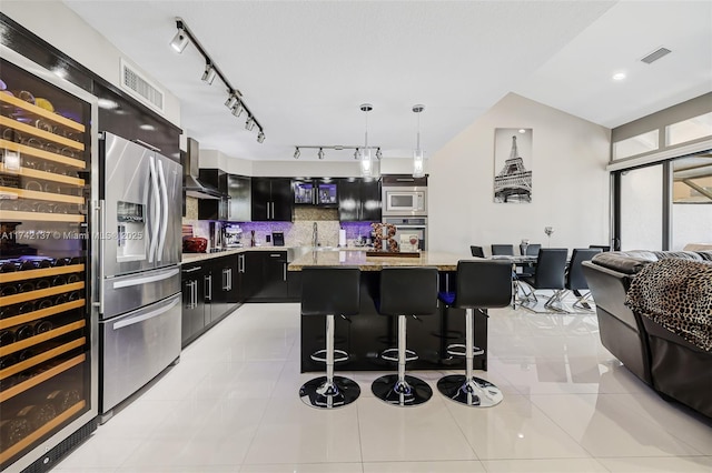 kitchen featuring a breakfast bar area, hanging light fixtures, light tile patterned floors, appliances with stainless steel finishes, and a kitchen island