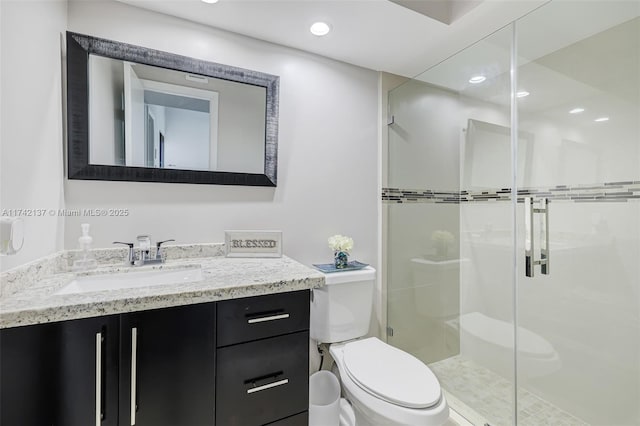 bathroom featuring vanity, an enclosed shower, and toilet