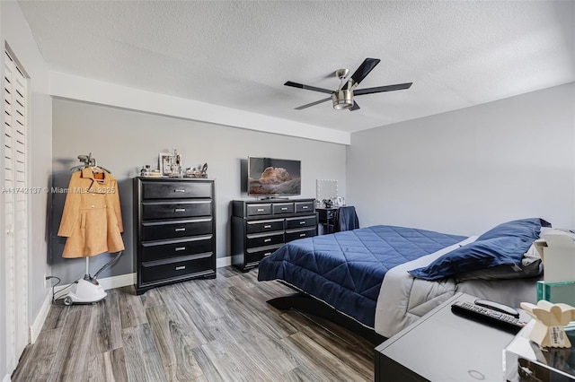 bedroom with wood-type flooring, ceiling fan, and a textured ceiling