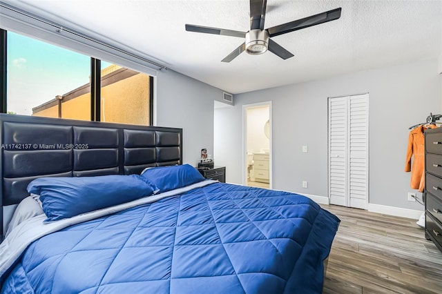 bedroom with wood-type flooring, connected bathroom, ceiling fan, and a textured ceiling