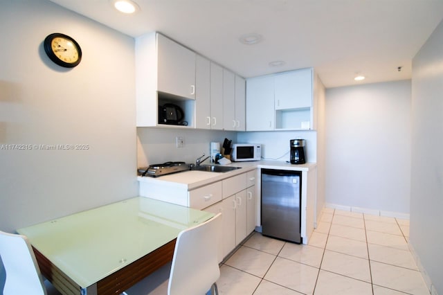 kitchen featuring white cabinetry, fridge, sink, and light tile patterned floors