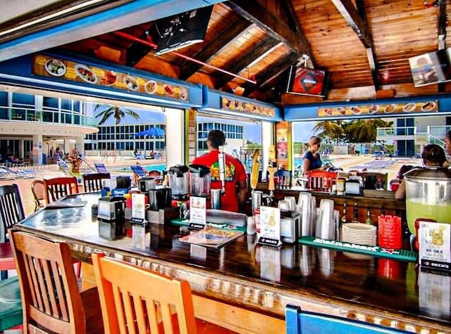 bar with vaulted ceiling with beams and wood ceiling