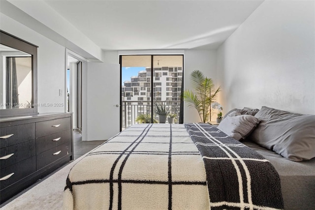 bedroom featuring access to exterior and a wall of windows