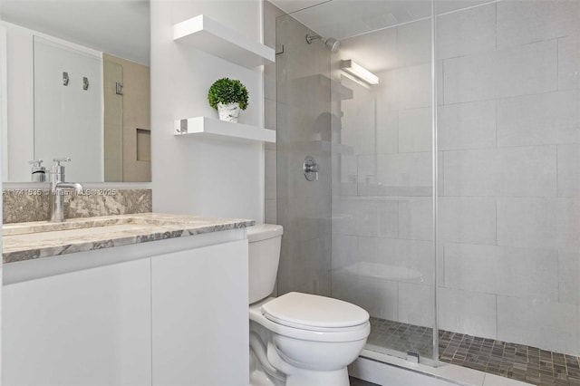 bathroom featuring vanity, toilet, and a shower with door