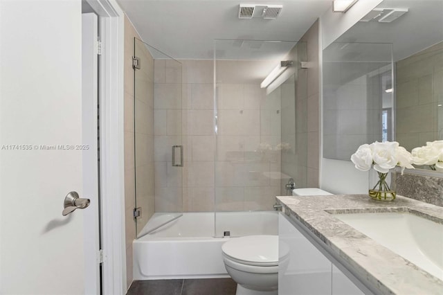 full bathroom with toilet, vanity, and shower / bath combination with glass door