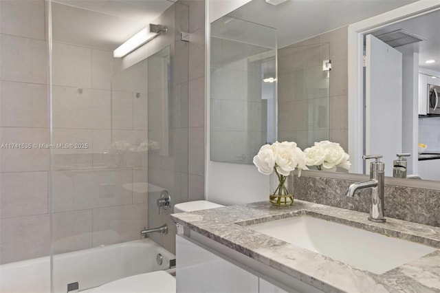 full bathroom featuring vanity, toilet, and tiled shower / bath combo