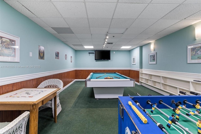 playroom featuring dark colored carpet, a paneled ceiling, wood walls, and billiards