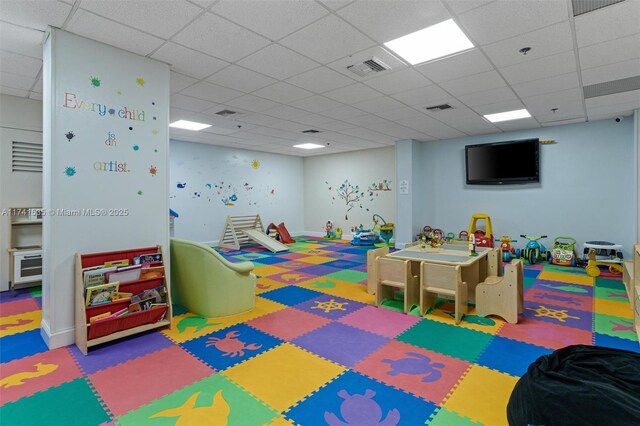 recreation room featuring carpet floors and a drop ceiling