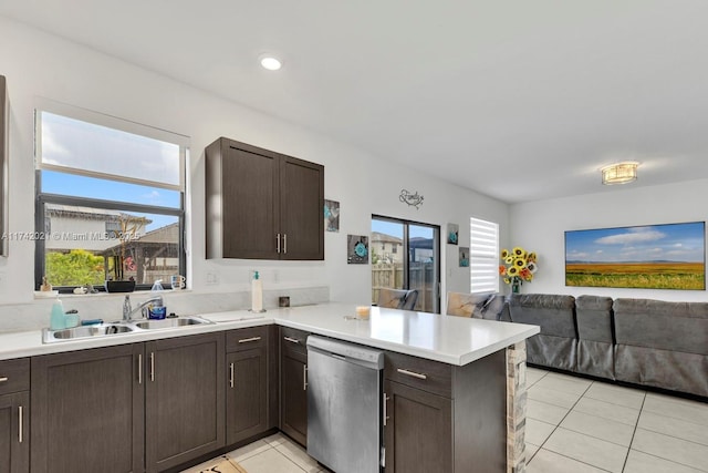 kitchen featuring sink, dark brown cabinets, light tile patterned floors, stainless steel dishwasher, and kitchen peninsula