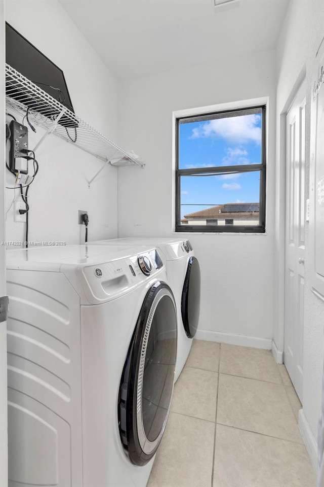 laundry area featuring washer and clothes dryer and light tile patterned floors