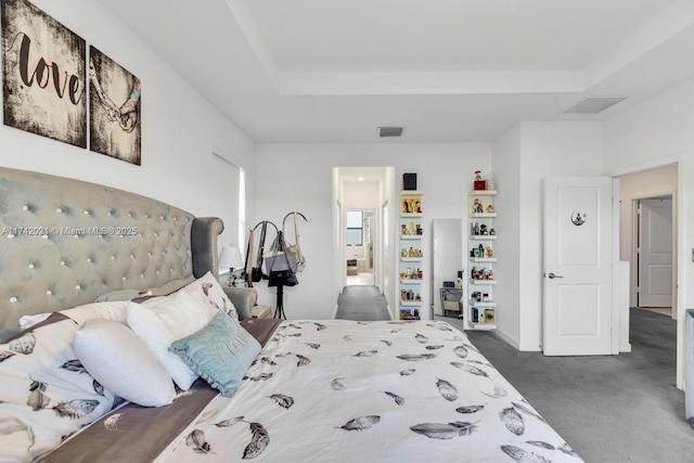 carpeted bedroom with a raised ceiling