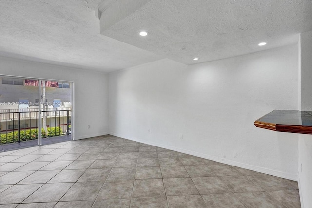 empty room with recessed lighting, a textured ceiling, and tile patterned flooring