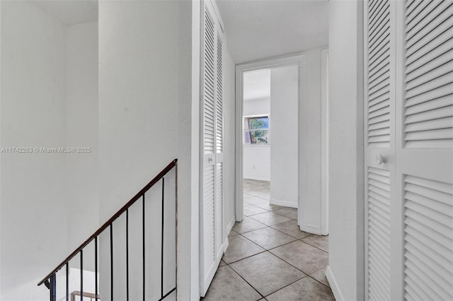 corridor featuring baseboards and tile patterned floors