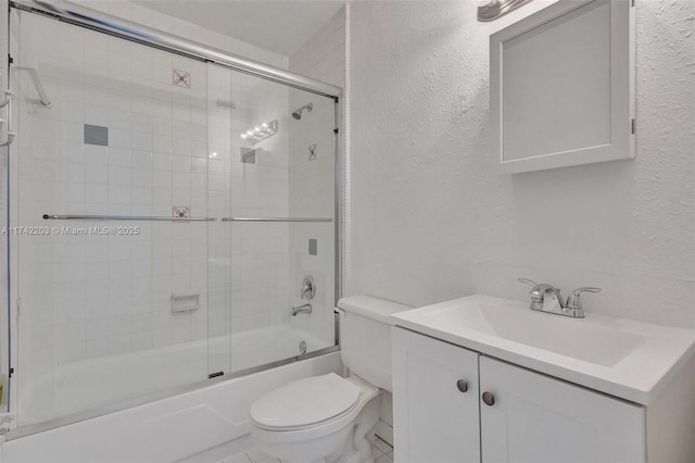 bathroom with a textured wall, vanity, enclosed tub / shower combo, and toilet