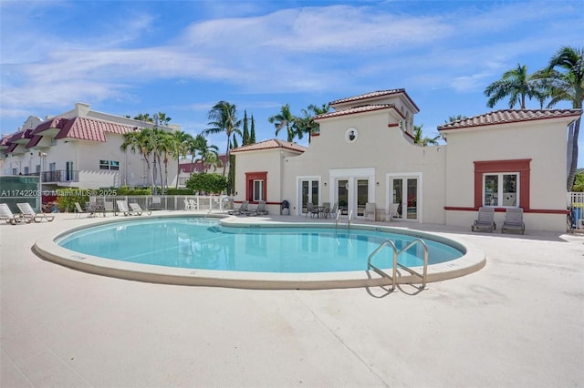 community pool featuring fence, a patio area, and french doors