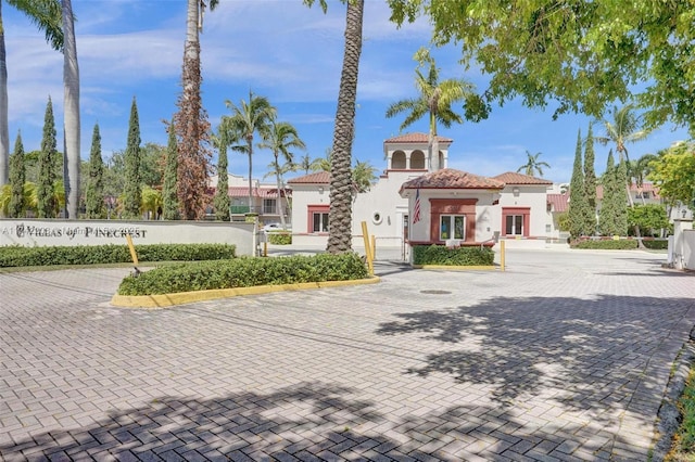 mediterranean / spanish home featuring a gate, a tile roof, fence private yard, and stucco siding
