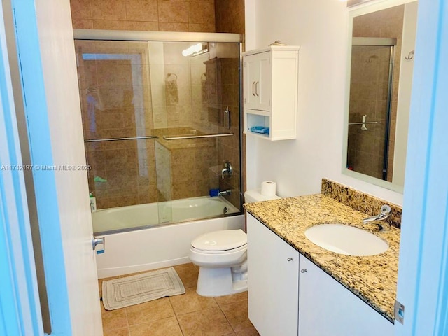 full bathroom featuring tile patterned flooring, vanity, shower / bath combination with glass door, and toilet