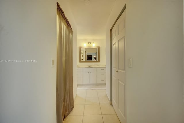 hallway featuring sink and light tile patterned floors