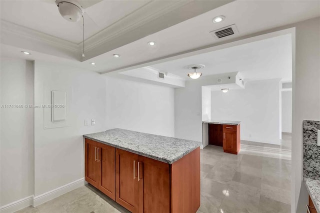 kitchen with light stone counters, crown molding, and kitchen peninsula